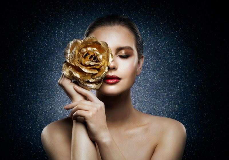 women holding golden rose on her eye