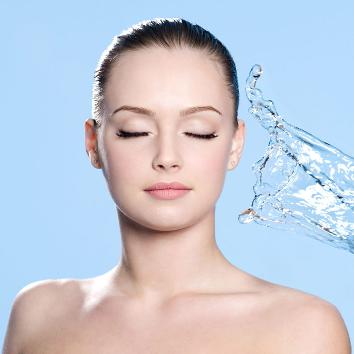 woman with eyes closed to splash of water