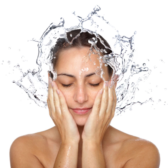 woman with her hands splashing her face